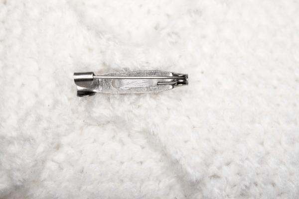 Hand knitted brooch in white with purple pearl
